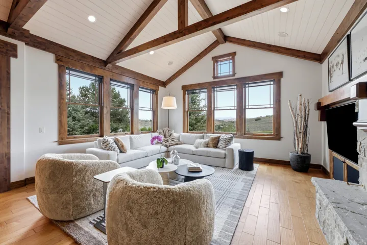 Vaulted ceiling with exposed wood beams and white paneling