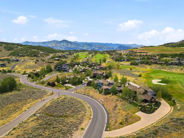 Expansive mountain landscape featuring a community of homes, a golf course, and paved roads