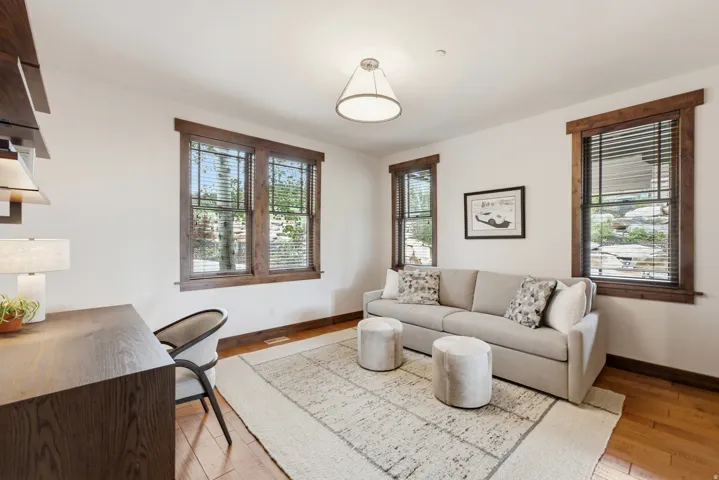 Spacious interior featuring multiple windows with wood-frame trim, hardwood flooring, and neutral wall tones