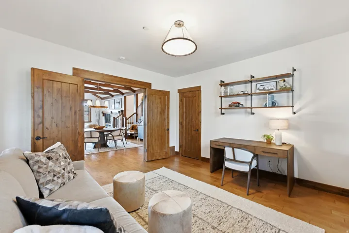 Spacious interior featuring wood-finish flooring, white walls, and a contemporary ceiling light fixture