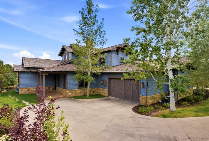 Contemporary rustic exterior with blue siding and stone veneer accents