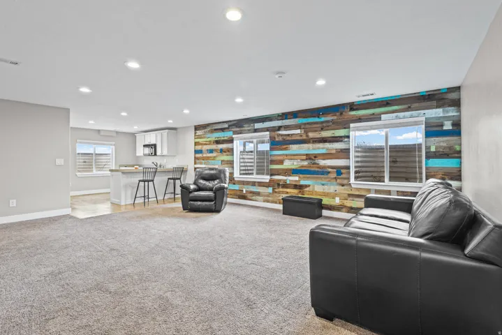 Spacious open-concept room featuring a striking accent wall with multi-toned wood planking
