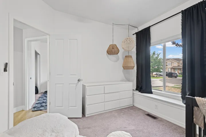 Bright room featuring a large window, neutral carpet, and white trim