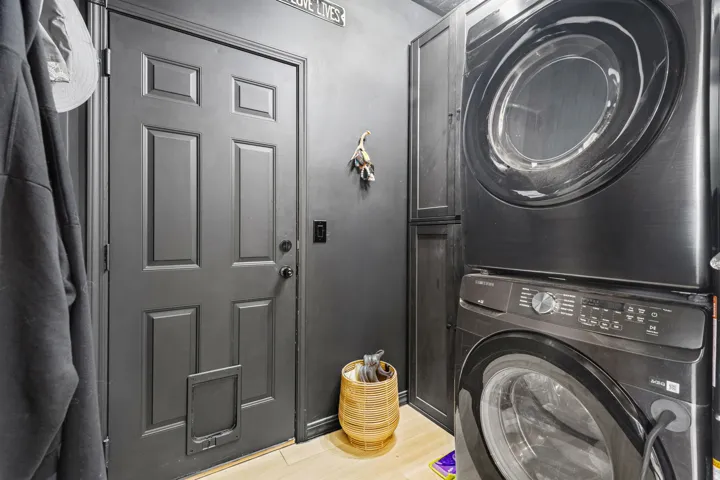 Laundry area featuring adjacent built-in cabinetry, and light wood-finish flooring
