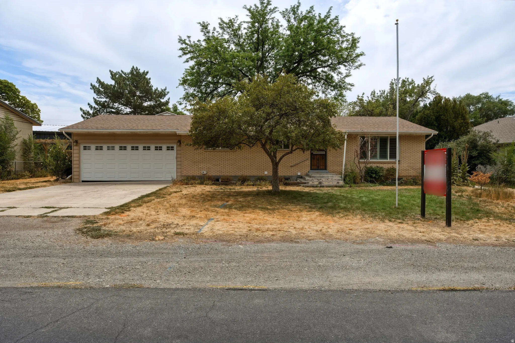 Ranch-style residence featuring a brick facade and an attached two-car garage with a panel door
