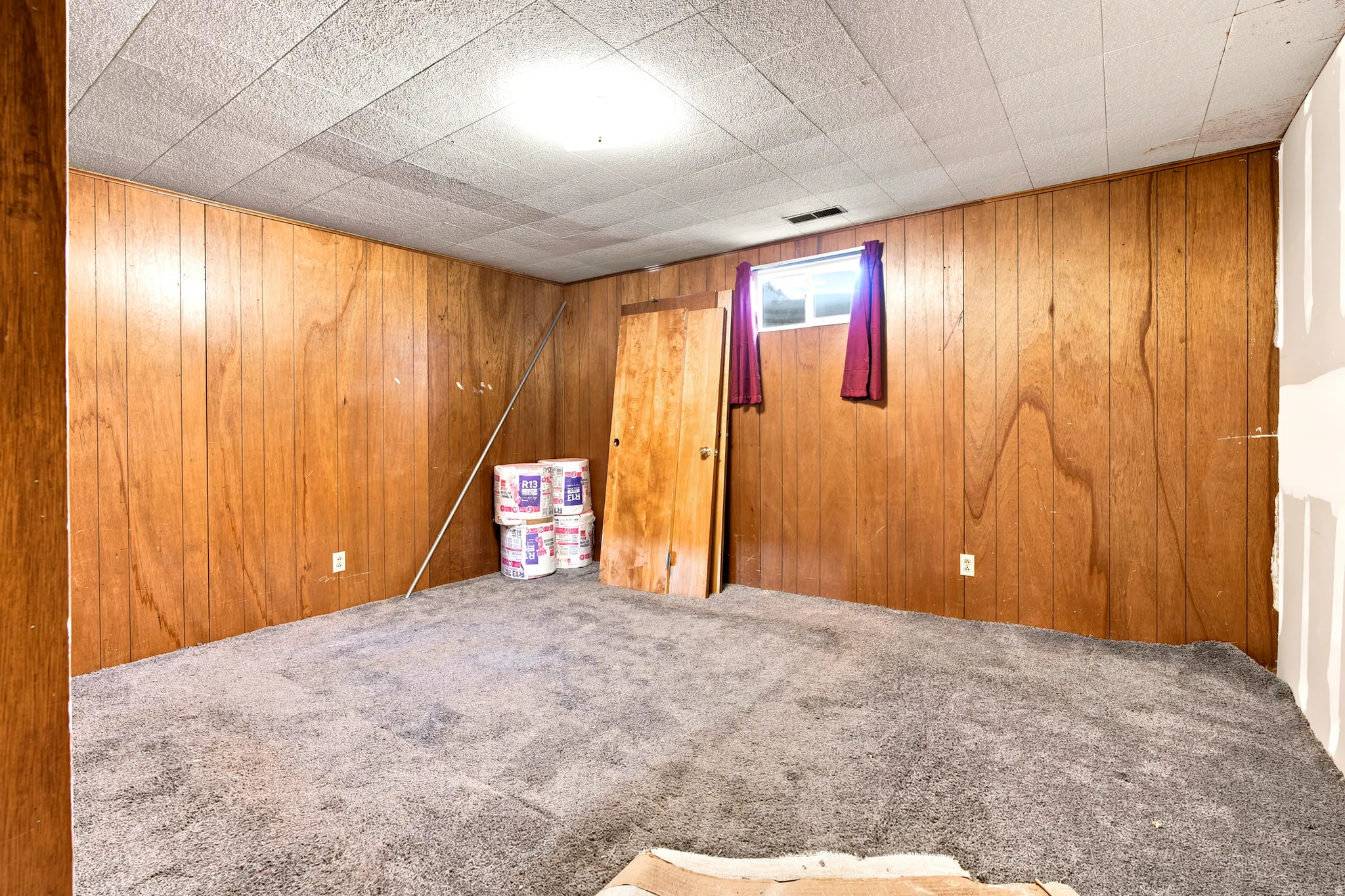 Carpeted interior space featuring wood paneling