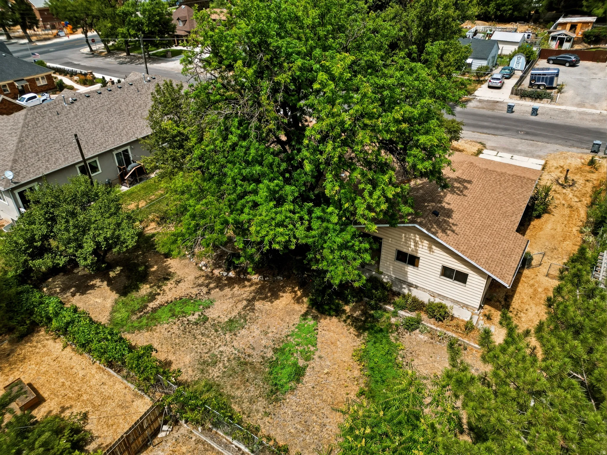 Residential property with a light-colored siding exterior and a brown shingle roof