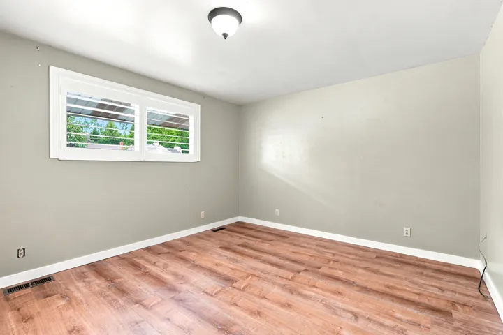 Room featuring wood-finish flooring, neutral wall tones, and white baseboards