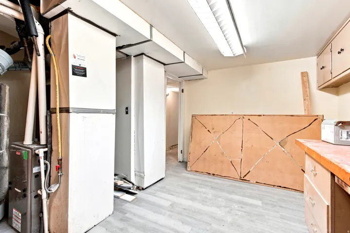 Utility area featuring a furnace system, water heater, and light wood-finish flooring