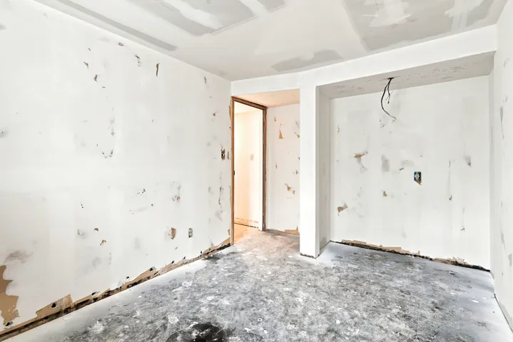 Unfinished interior space with exposed wallboard and concrete flooring