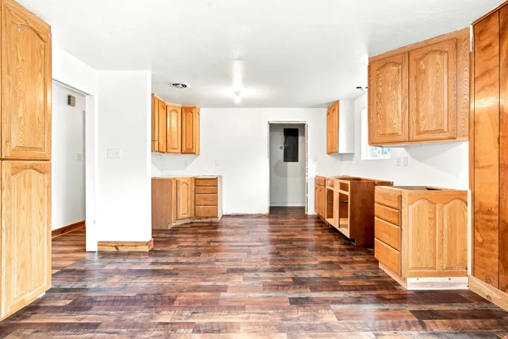 Kitchen area featuring wood-finish flooring, light-toned cabinetry, and white walls