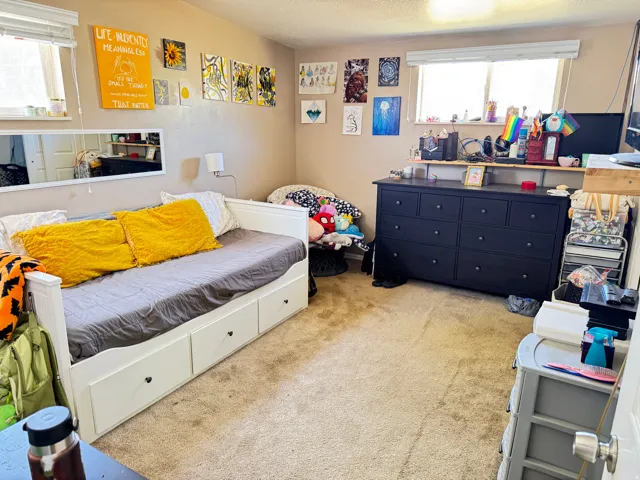 Bedroom featuring neutral wall paint, two windows for natural light, and a built-in daybed with three storage drawers
