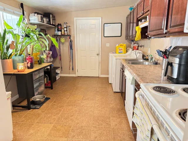 Expansive kitchen with ceramic tile flooring, laminate countertops, and wood-finish cabinetry