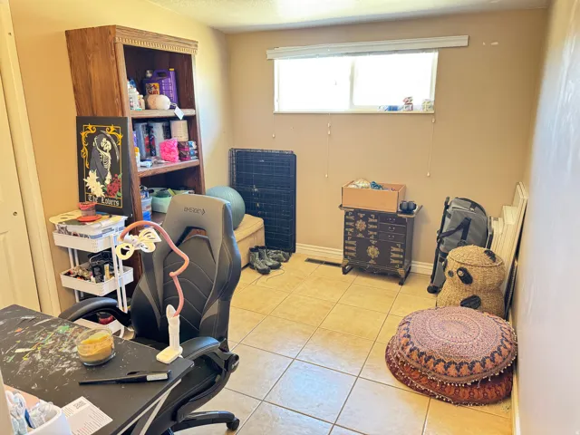 Room featuring light beige walls and light-toned tile flooring
