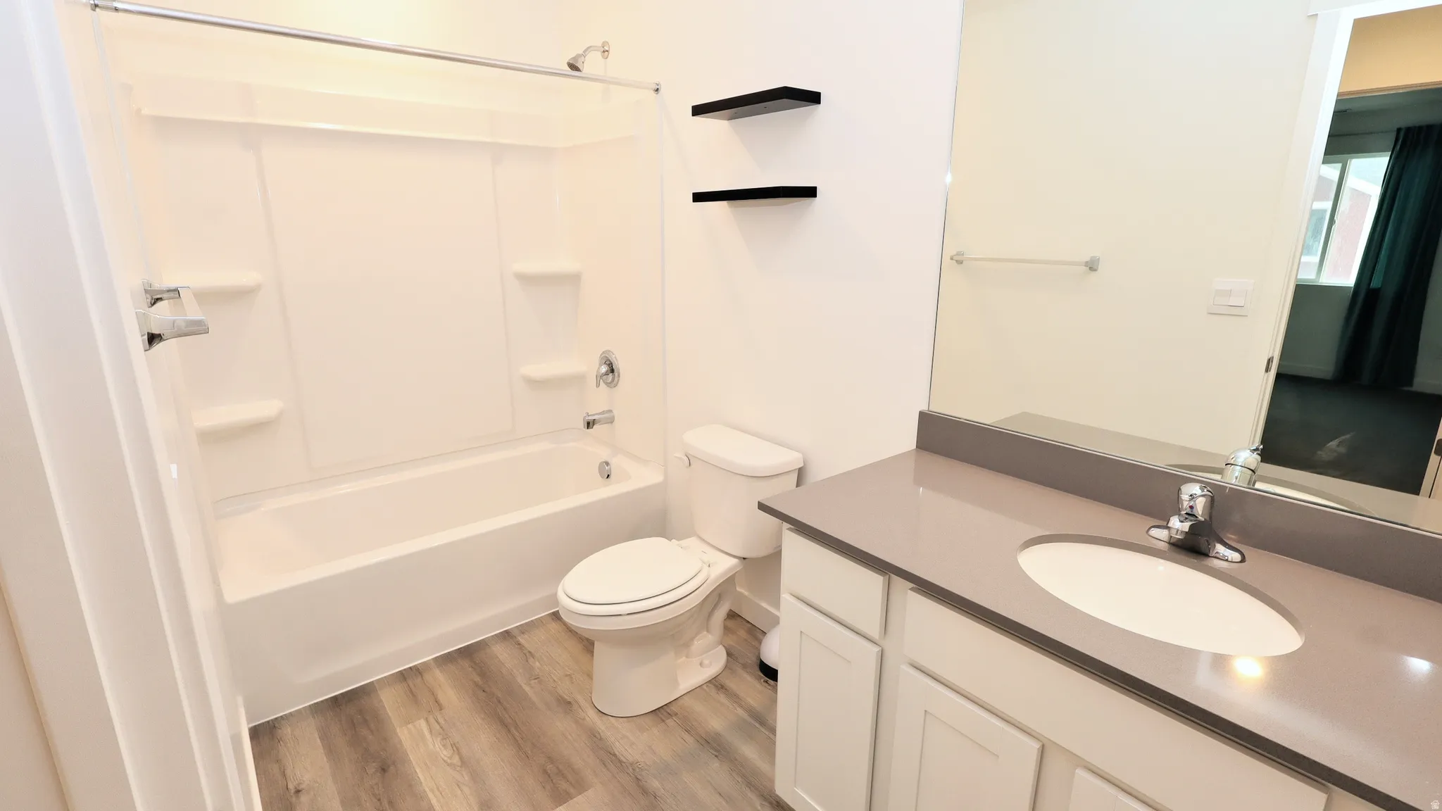 Contemporary bathroom featuring a single vanity with a gray countertop, an undermount sink, and white cabinetry