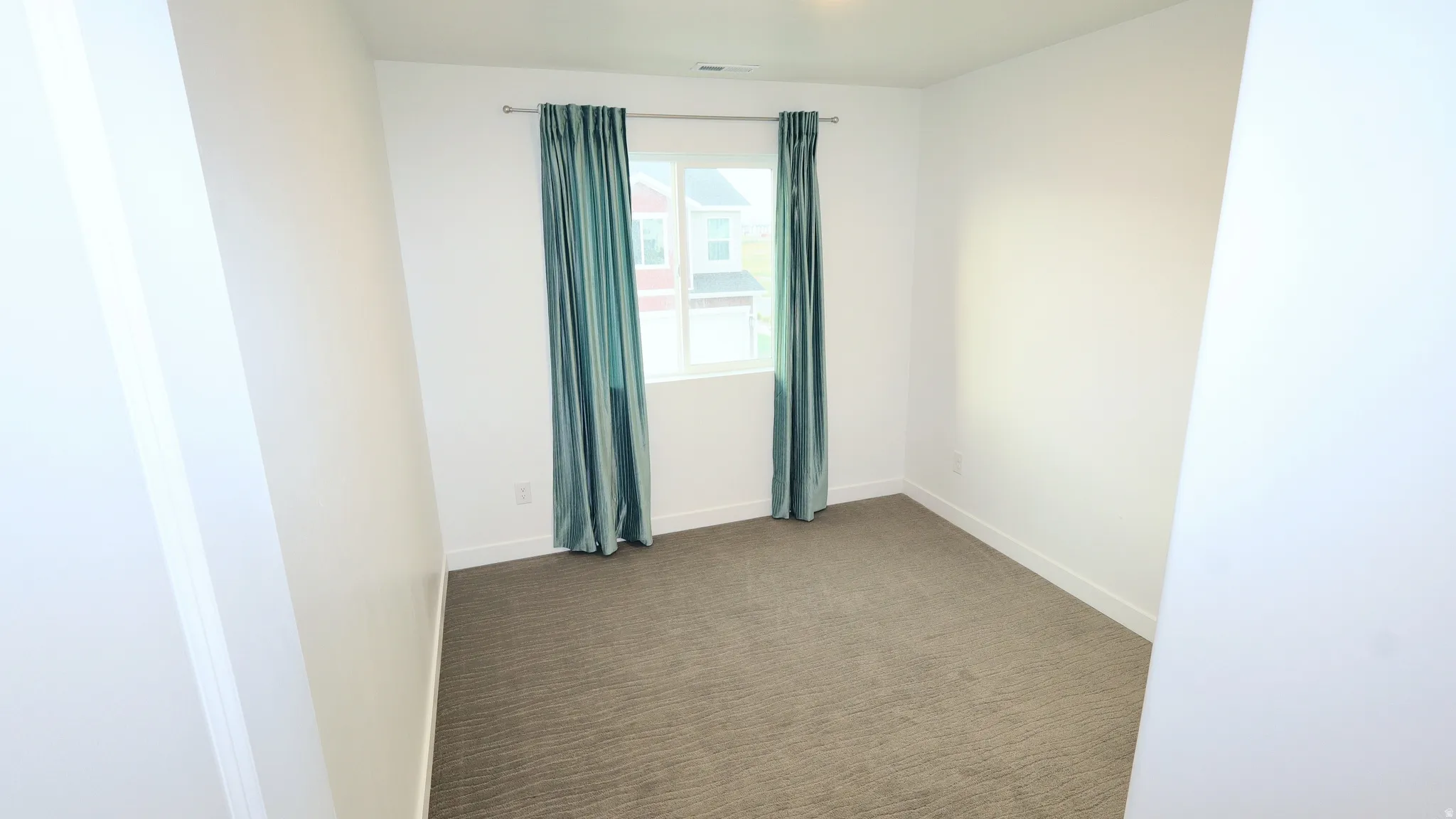 Neutral-toned carpeting extends throughout this room, complemented by white walls and trim