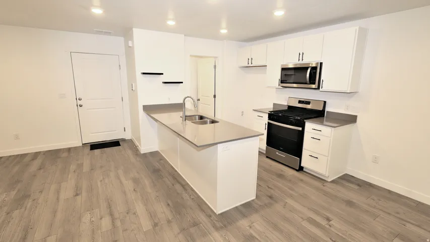 Open-concept kitchen with a central island featuring a double-basin stainless steel sink and a contemporary faucet