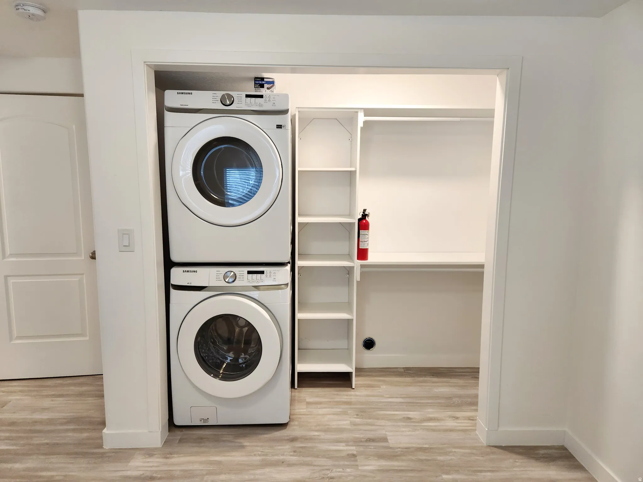 Laundry closet featuring stacked front-loading washer and dryer units