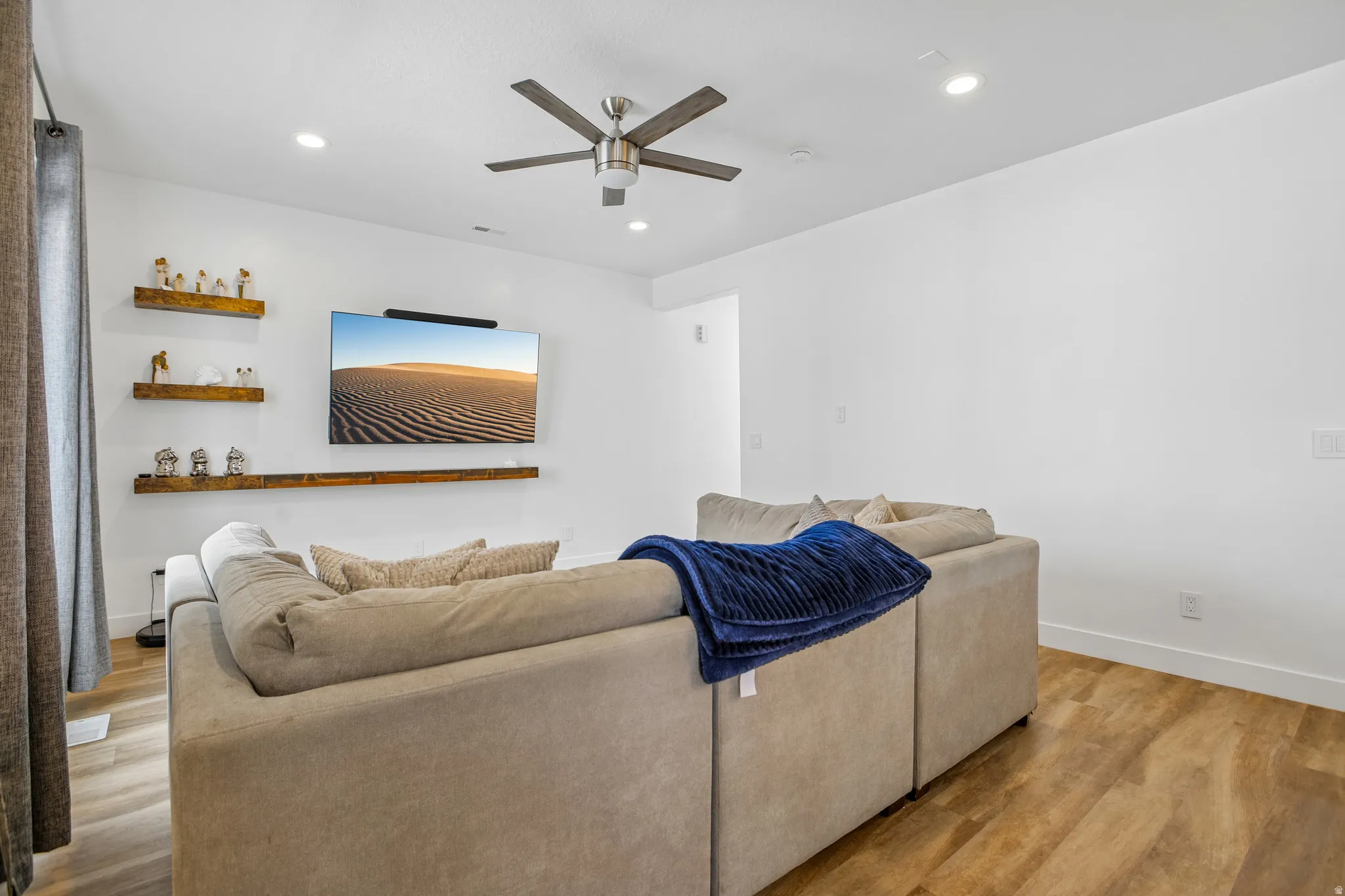 Living area featuring wood-finish flooring, recessed lighting, and a ceiling fan