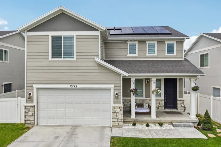 Contemporary two-story residence featuring light gray horizontal siding and a dark shingle roof