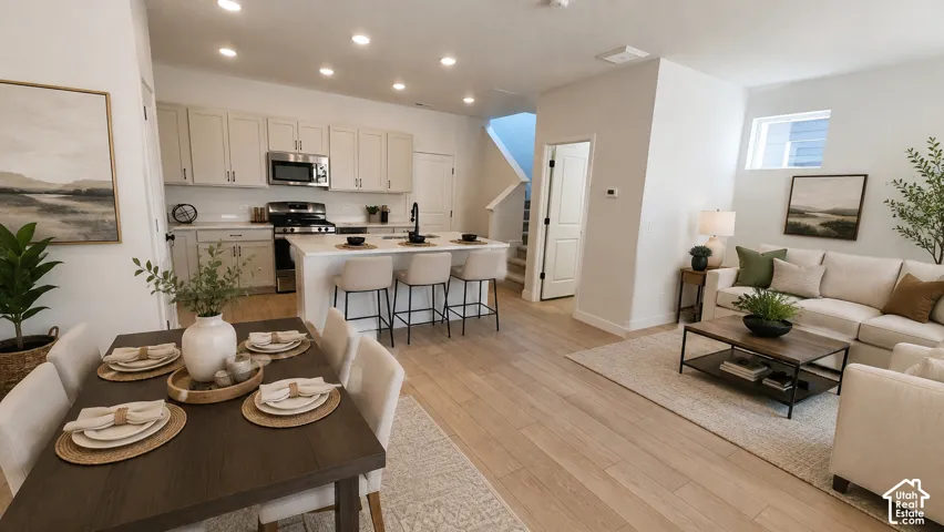 Open-concept living area featuring wood-finish flooring, recessed lighting, and white walls