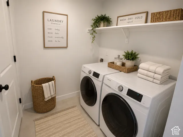 Dedicated laundry area featuring modern front-loading appliances, a single floating shelf, and neutral wall tones
