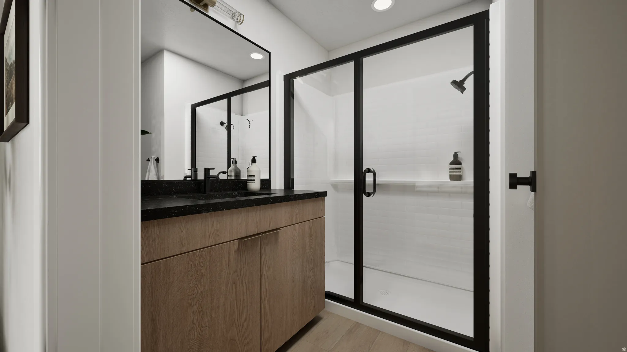 Bathroom featuring a wood-finish vanity with a dark countertop and black fixtures