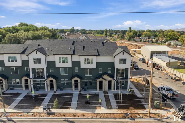 Multi-unit townhouse complex featuring two-tone siding, architectural shingle roofing, and concrete walkways