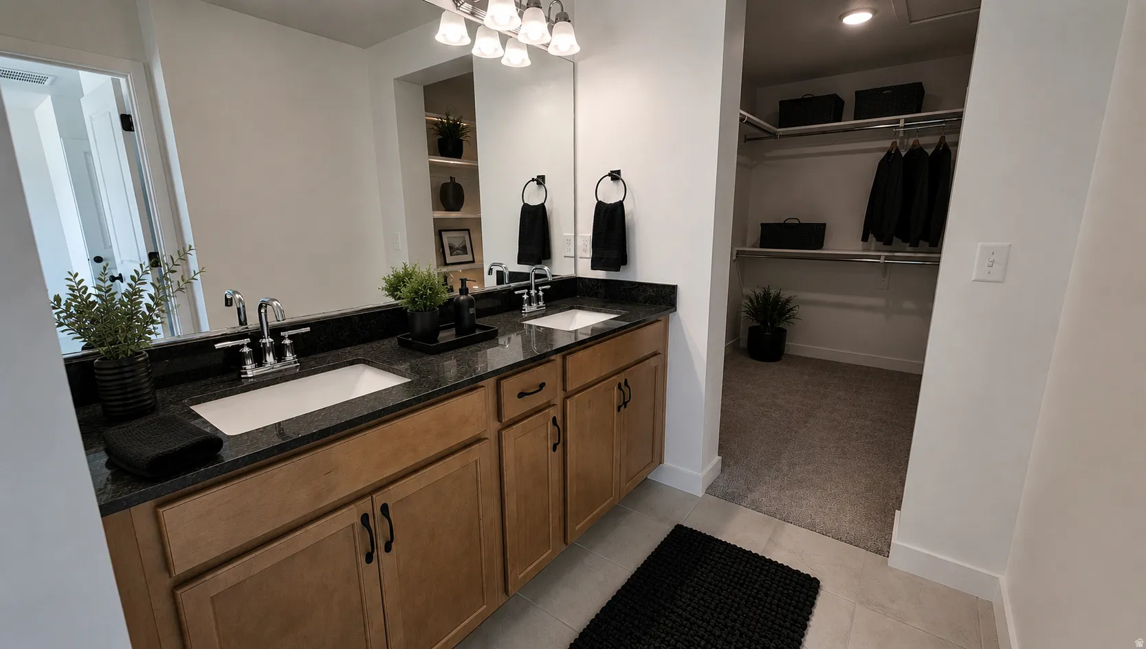 Dual vanity with granite countertop and undermount sinks, wood cabinetry, chrome fixtures, and a recessed medicine cabinet