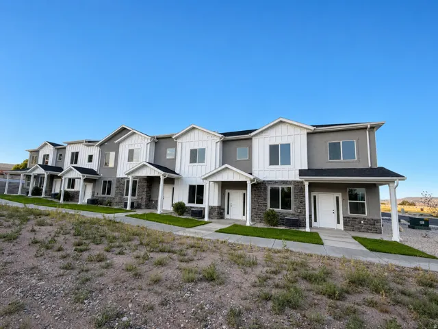 Modern townhome with multi-tone exterior siding, featuring white board-and-batten accents and gray stucco
