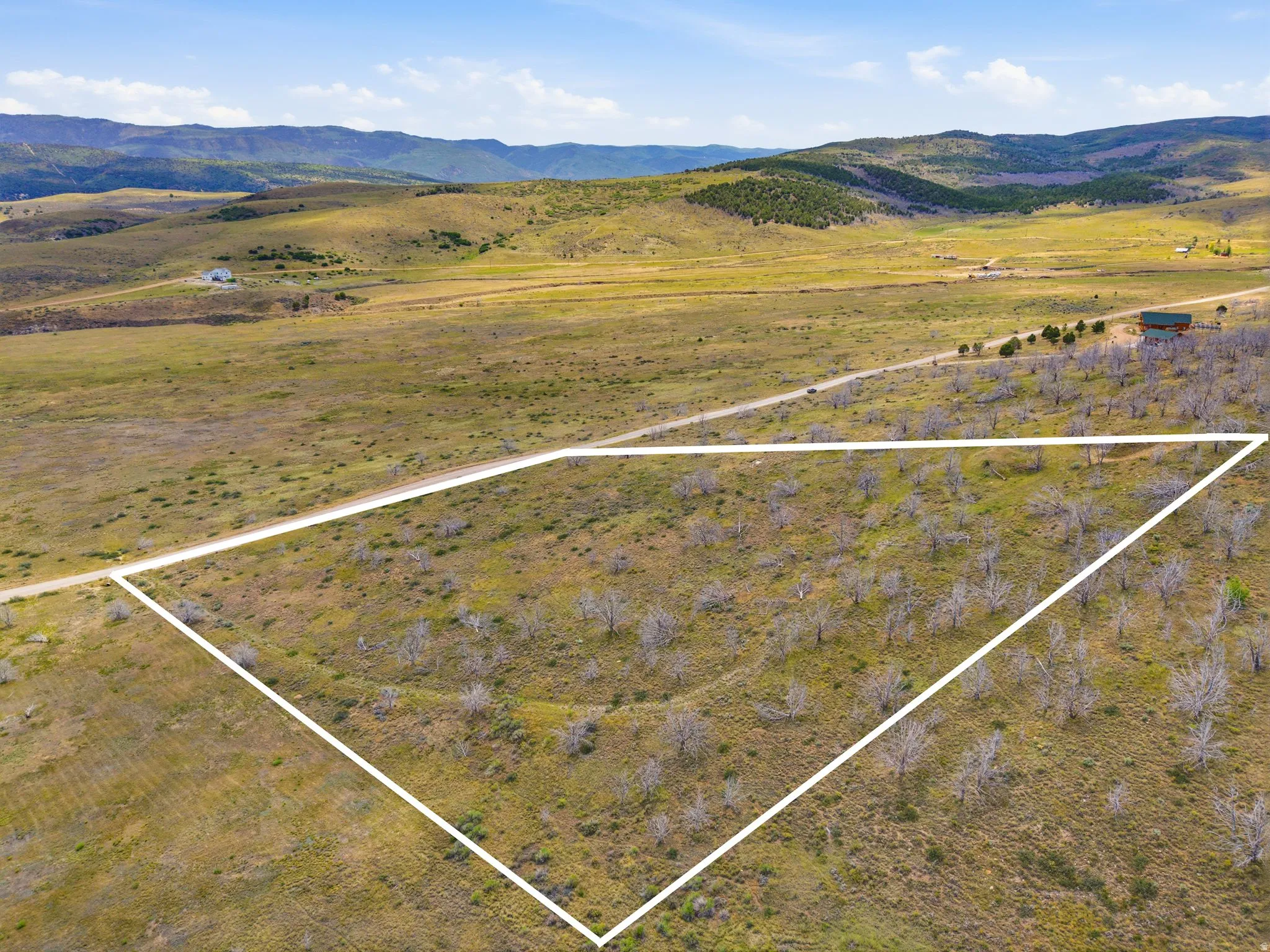Expansive land parcel featuring natural terrain and distant mountainous backdrop