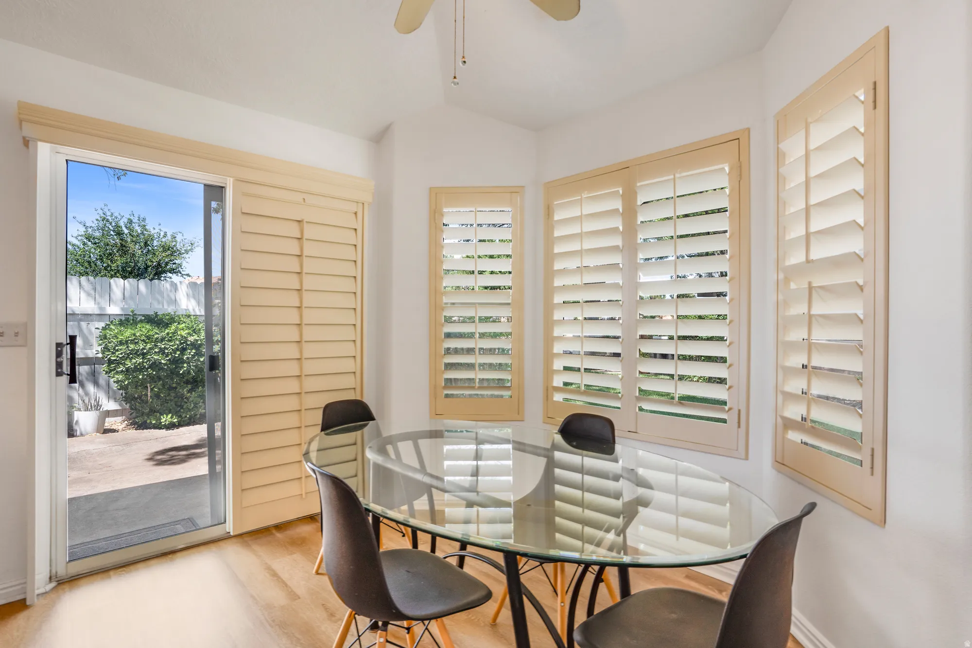 Bright dining area featuring wood-finish flooring and a glass sliding door providing outdoor access