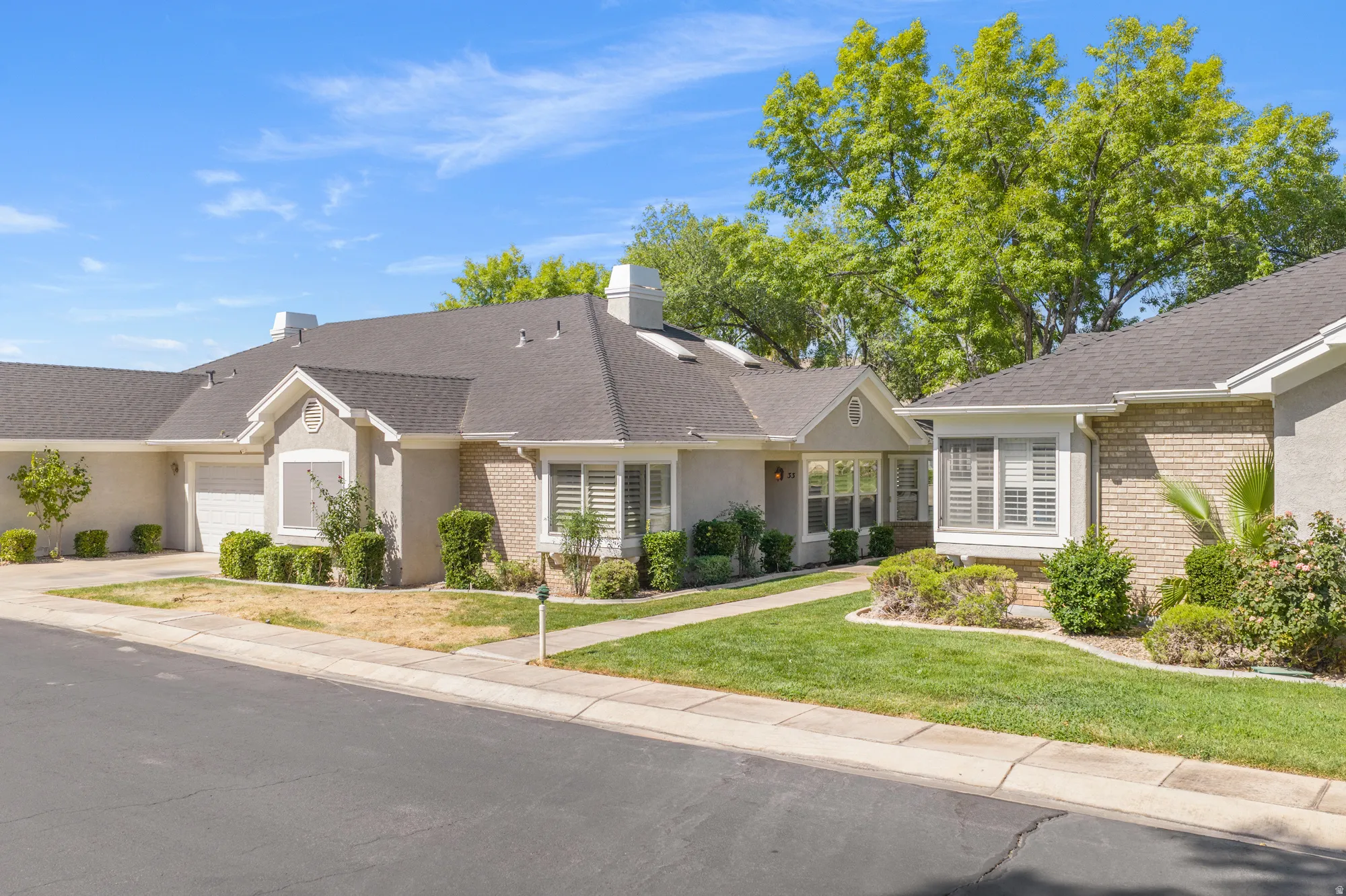 Traditional-style property featuring a pitched roofline and a combination of stucco and brick siding
