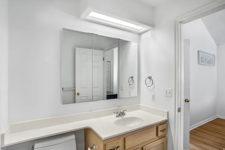 Bathroom vanity featuring an integrated sink, laminate countertop, and wood-finish cabinetry