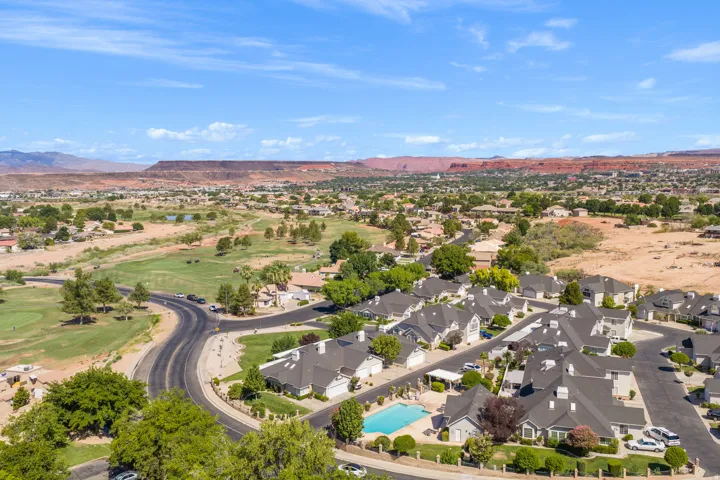 Residential community featuring a curved street layout, a central swimming pool, and uniform rooflines