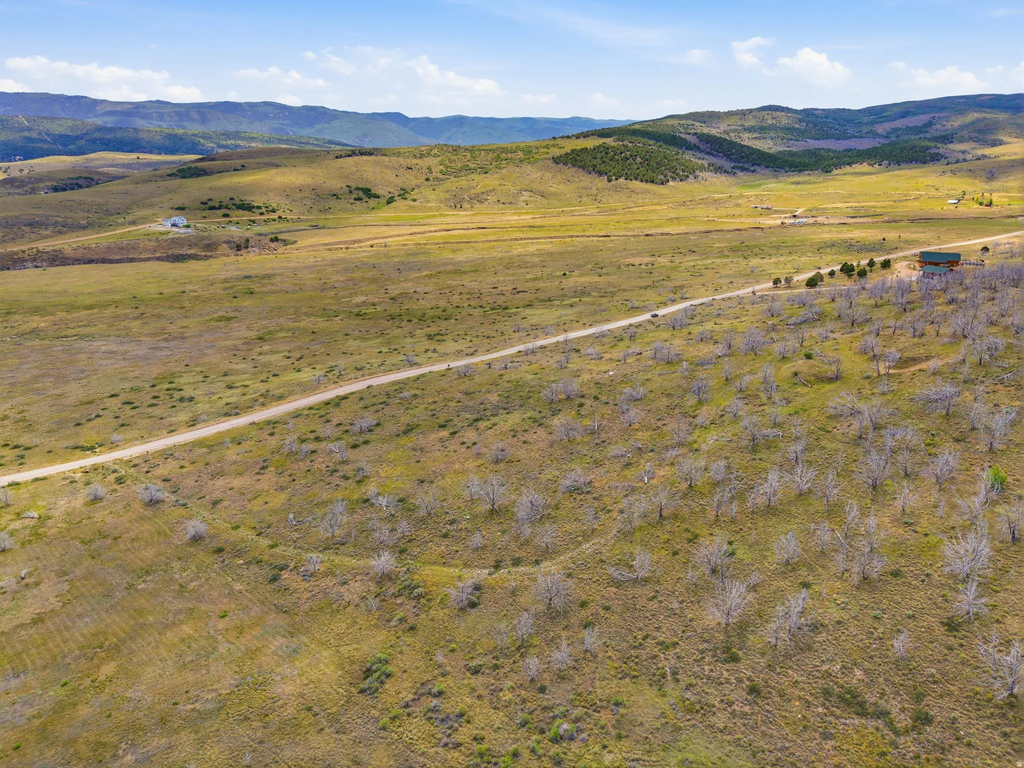 Expansive land featuring a dirt road and distant mountainous terrain