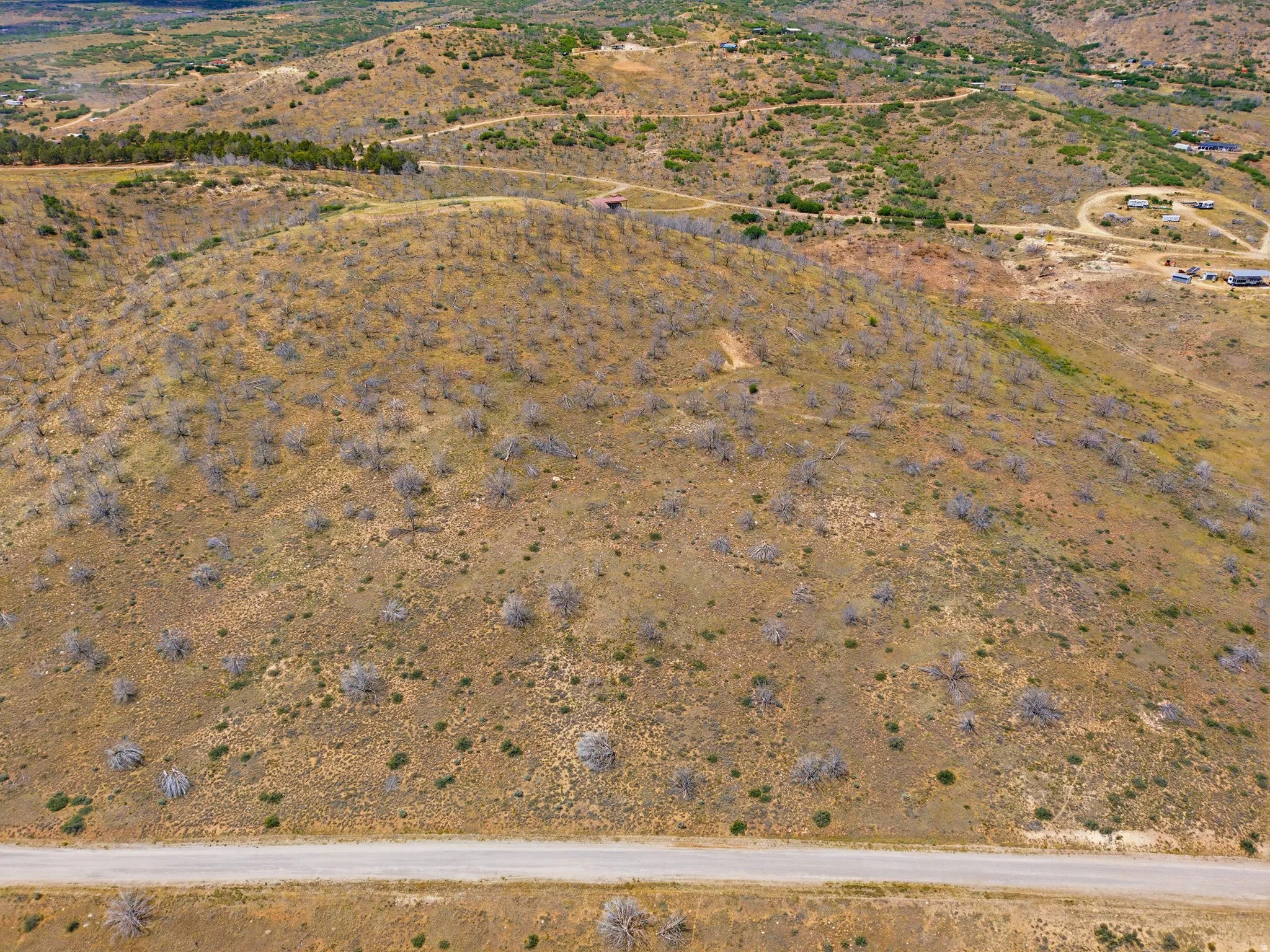 Expansive undeveloped land parcel featuring rolling hills and natural ground cover