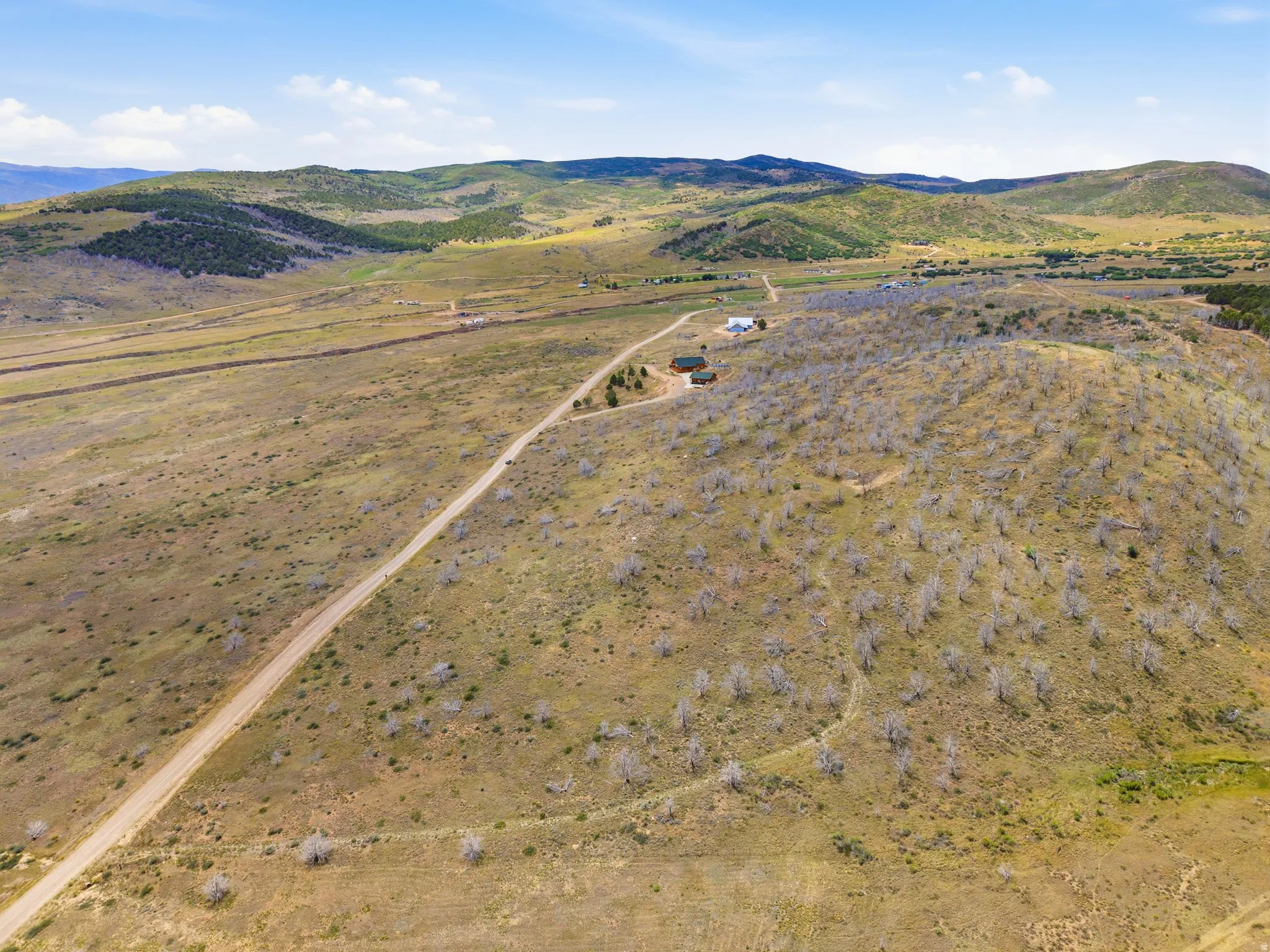Expansive rural landscape featuring rolling hills and distant mountains