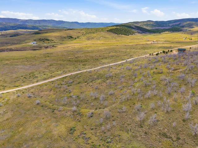 Expansive land featuring a dirt road and distant mountainous terrain
