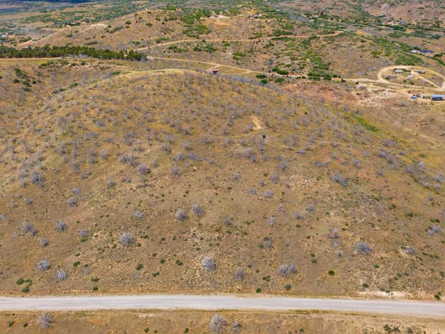 Expansive undeveloped land parcel featuring rolling hills and natural ground cover