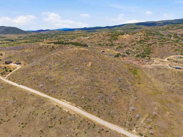 Expansive rural landscape featuring a dirt road and scattered vegetation