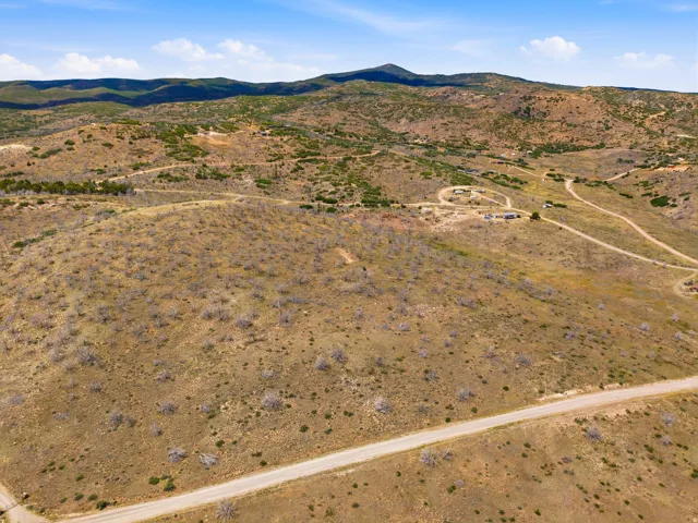 Expansive undeveloped land featuring a winding road and distant mountainous terrain