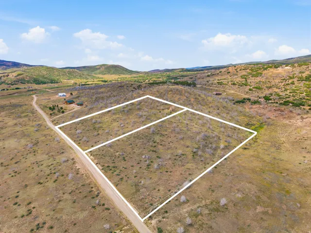 Expansive land parcels with natural terrain, surrounded by distant mountains