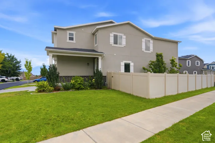Two-story residence featuring light gray siding, dark roofing, and white window shutters