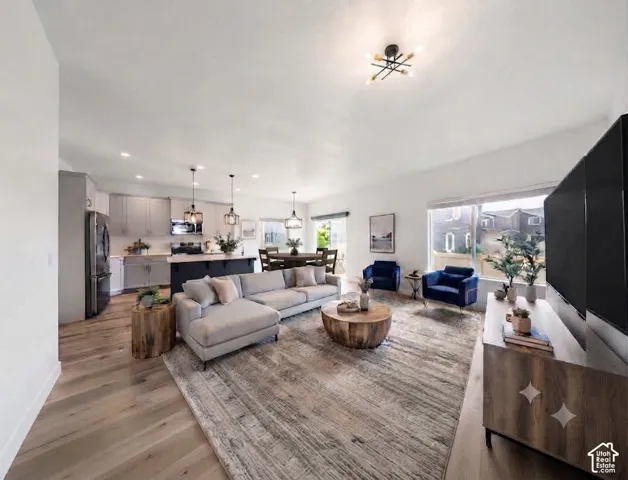 Open-concept living space featuring wood-finish flooring, recessed lighting, and a modern ceiling fixture