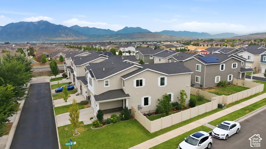 Contemporary residential architecture featuring light beige stucco exteriors and dark shingle roofing