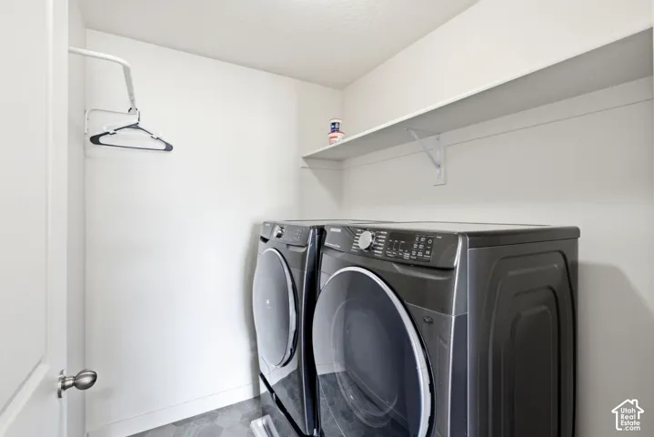 Dedicated laundry area featuring a wall-mounted drying rack and a spacious storage shelf