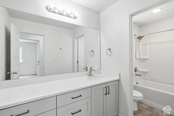 Bathroom featuring a spacious vanity with white countertop, integrated sink, and brushed nickel faucet