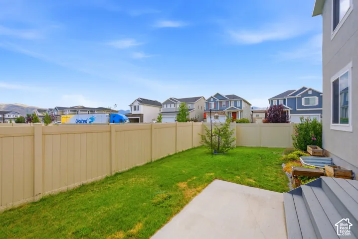 Rear yard featuring a concrete patio, composite steps, and a tan privacy fence