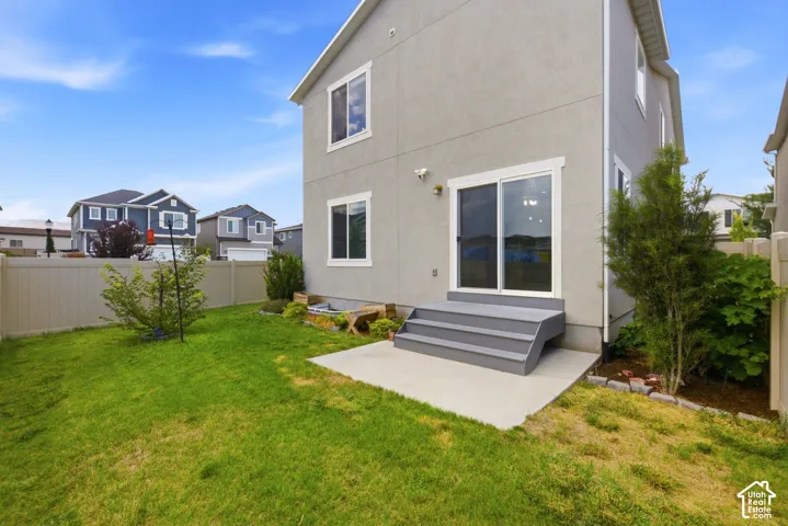 Private backyard featuring a sliding glass door entry to the home, a concrete patio, and a three-step exterior staircase